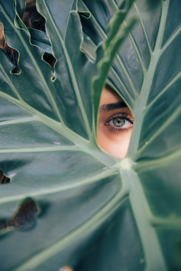 Woman looking through leaf